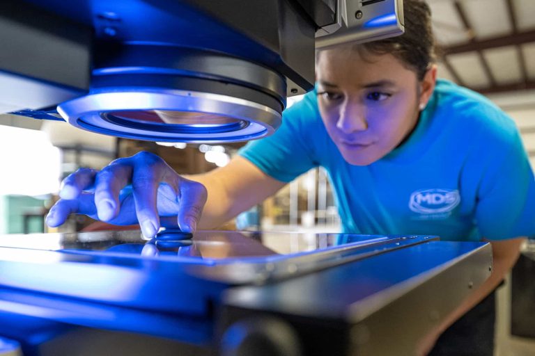 Team member uses microscope to examine plastic ring.