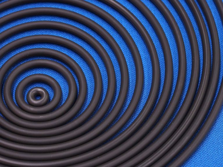 Black circular plastic rings on a blue background.